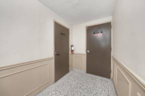 a hallway with two doors and white walls