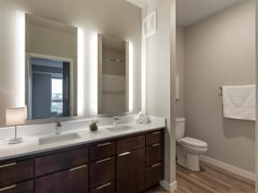 Bathroom with double vanity and backlit mirrors