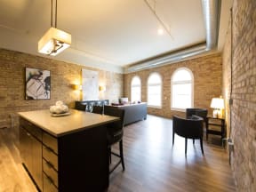 Apartment living room with exposed brick wall and large arched windows