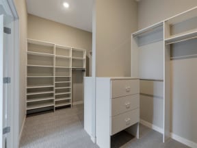 large main bedroom walk-in closet with custom shelving and storage