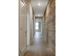 apartment hallway with exposed brick wall and gallery lighting