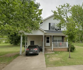 A house with a car parked in front.