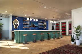 A bar with a green counter and stools is shown.