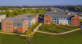 A large building complex with a green lawn in front.
