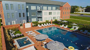 A large swimming pool surrounded by lounge chairs and umbrellas.