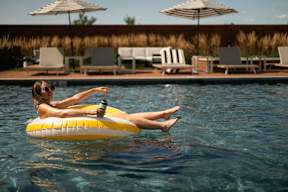 A woman is floating on a yellow float in a pool.