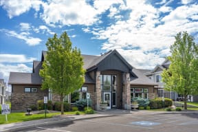the exterior of a building with trees and a parking lot