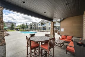 a patio with a table and chairs next to a pool