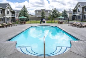 our apartments have a resort style pool with chairs and tables