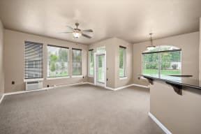 an empty living room with a ceiling fan and a window