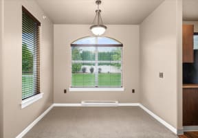 an empty room with a large window and a carpet