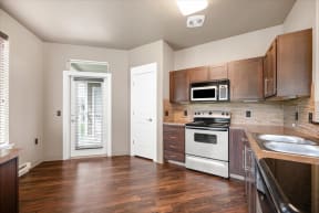 an empty kitchen with wooden cabinets and a white stove