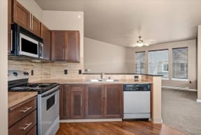 an empty kitchen with wooden cabinets and stainless steel appliances
