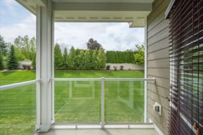a view of the backyard from a balcony with a glass door