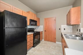 a kitchen with black appliances and wooden cabinets