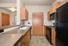 a kitchen with black appliances and wooden cabinets