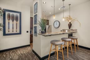 a bar with three stools and a clock on the wall