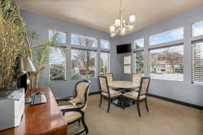 a dining room with a table and chairs and windows