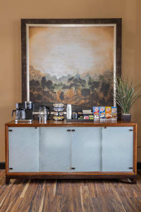 a coffee bar with a large painting on the wall above it