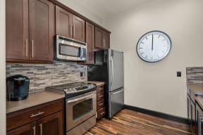 a kitchen with stainless steel appliances and a clock on the wall