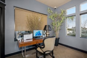 a home office with a desk and a window
