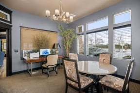 a dining room with a table and chairs and windows