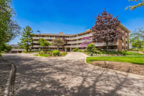 A large apartment complex with a paved driveway in front.