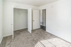 A white room with a carpeted floor and two doors.