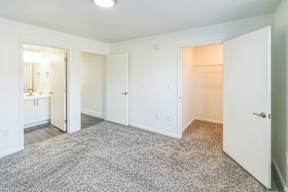 A white room with a carpeted floor and three doors.