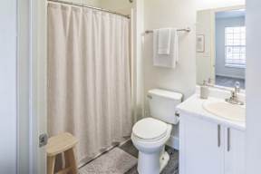 A white toilet sits next to a white sink in a bathroom.