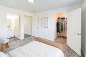 A bedroom with a bed, a wardrobe, and a vanity.
