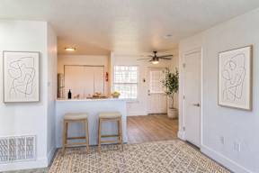 A kitchen with a bar and two stools.