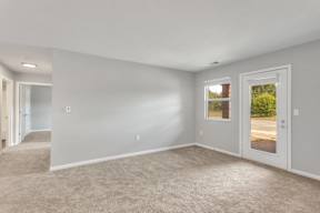 Living room with carpet and white walls at Arbor Crossings Muskegon MI