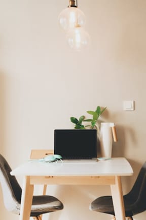 a laptop computer sitting on top of a wooden table