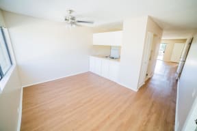 an empty living room and kitchen with wood floors