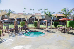a swimming pool at a resort with tables and umbrellas