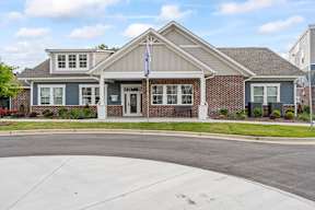 A house with a grey front and a flag on the front door.
