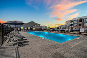 A swimming pool surrounded by lounge chairs and umbrellas at a resort.