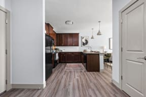 a kitchen with wood flooring and a black refrigerator at the Vue apartments in Indianapolis