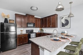 a kitchen with granite counter tops and wooden cabinets at the Vue apartments in Indianapolis