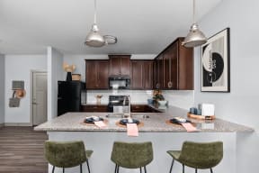 a rendering of a kitchen with an island and stools at the Vue apartments in Indianapolis