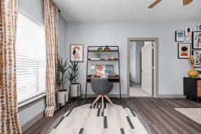 an office space with a desk and a chair and a large window at the Vue apartments in Indianapolis