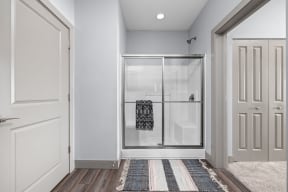 a closet with a glass door and a rug on the floor