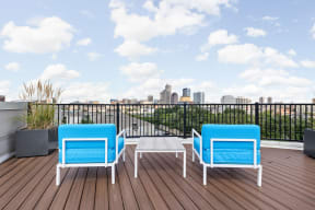 a balcony with blue chairs and a view of indianapolis in the background