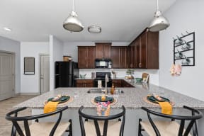 a kitchen with a granite counter top and a island with chairs