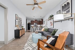 a living room with a couch and a chair and a ceiling fan