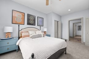 a bedroom with a bed and paintings on the wall