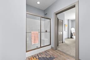 a walk in closet with a glass door and a door to a bathroom