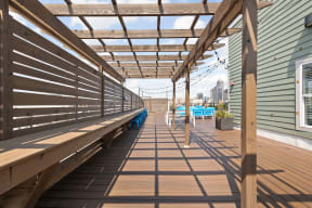 a covered deck with benches and a view of the indianapolis in the background at the vue luxury apartments