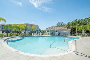 Pool with clubhouse in the background at Trillium luxury apartments in Melbourne fl